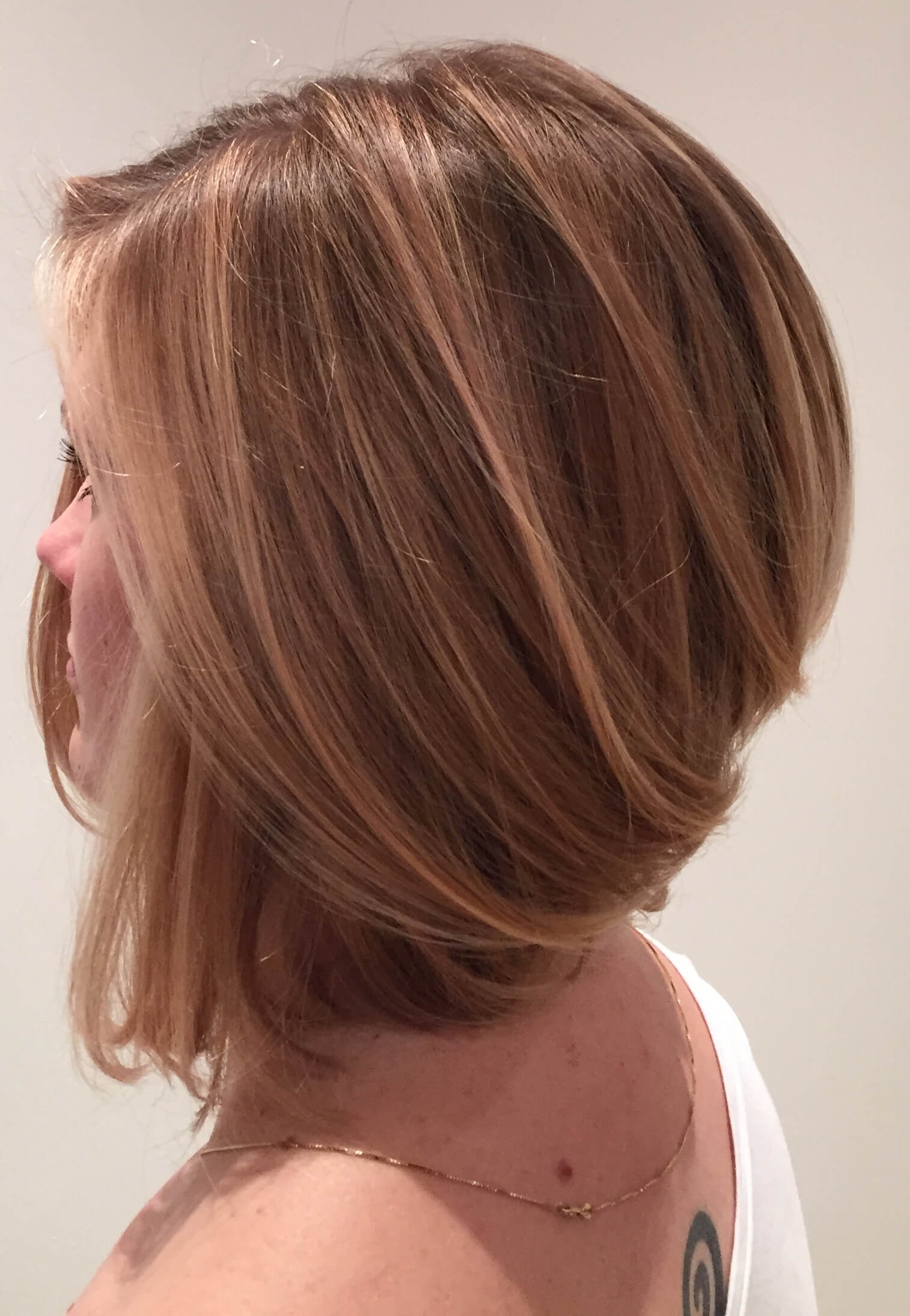 woman with chocalate and mahogany ombre concave bob  hairstyle with sharp edges at the frontal side.
